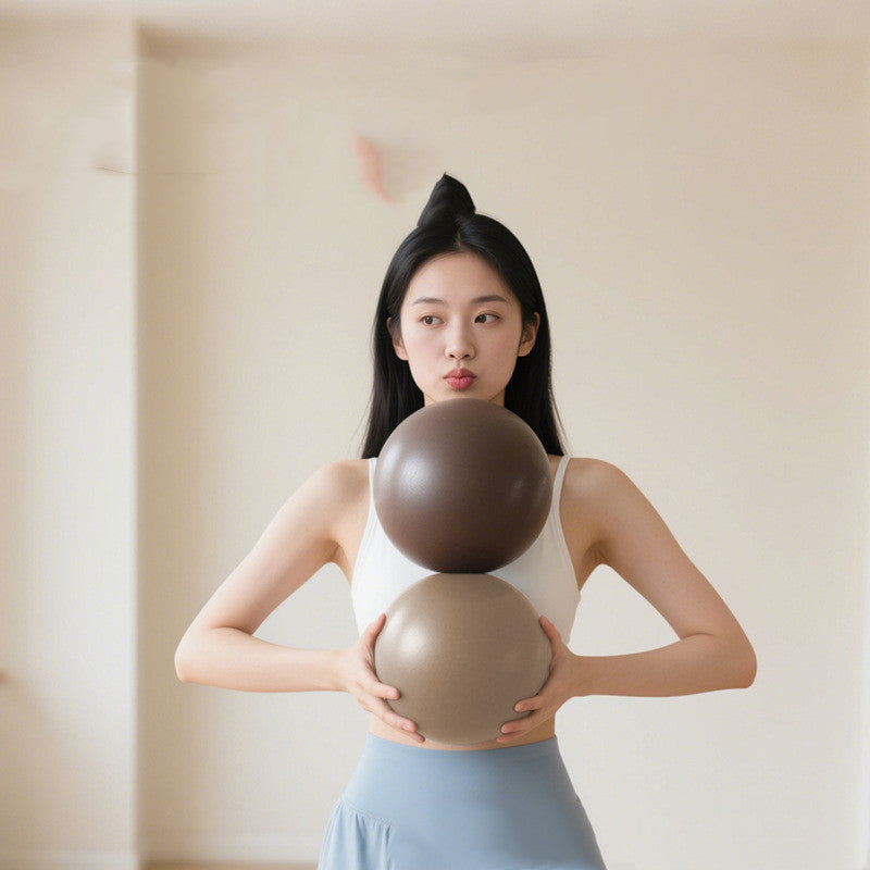 Woman holding two 8-Inch Mini Pilates Balls