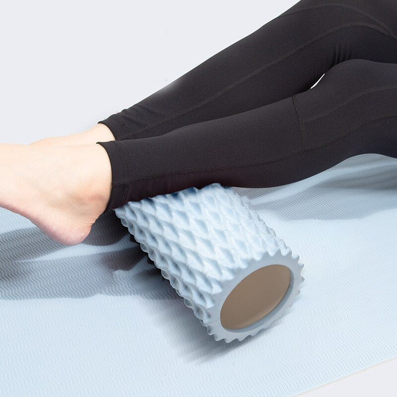 Wave-textured foam roller under the calves, blue